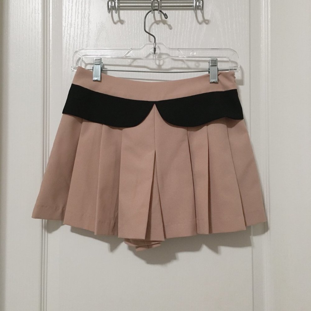Nude pleated skorts with black accents